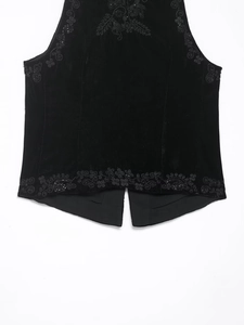 Close-up of black velvet vest with intricate floral embroidery and beaded detailing