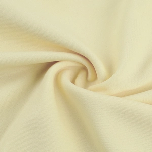Detail shot of elegant cream lace fabric showing soft texture and spiral pleated design