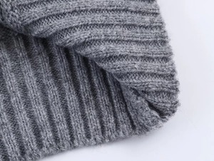 Vue détaillée du tricot côtelé gris montrant la texture épaisse de la laine et les mailles