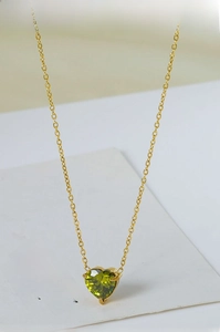 Detail shot of heart-shaped green zircon pendant on 18k gold plated titanium steel chain