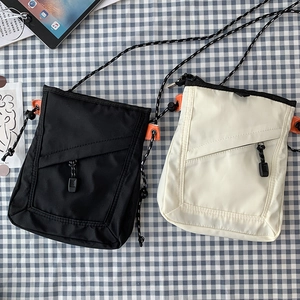 Detail of canvas mini messenger bags with adjustable straps and front zipper pockets
