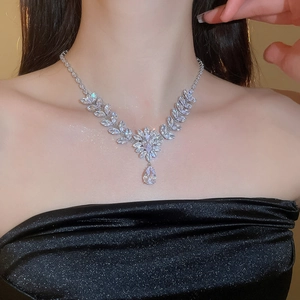 Close-up of leaf and flower zircon necklace with a pear-shaped drop pendant on model
