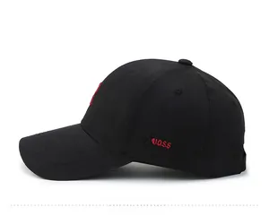 Dettaglio laterale di un cappello nero in cotone con logo KUOSS ricamato in rosso