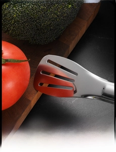 Macro detail of mirror-polished stainless steel food tongs with three slotted drainage holes