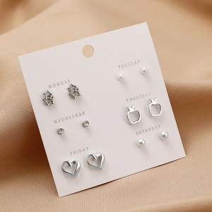 Detail of multi-style stud earring set with stars and pearls on weekday cards