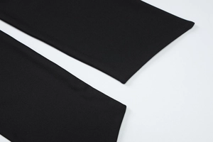 Detailed close-up of high-quality black knit fabric texture and fine stitching for the set