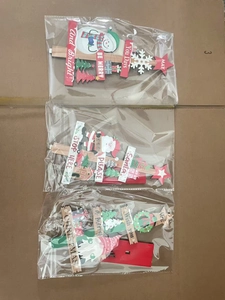 Detailed view of three festive wooden Christmas ornaments featuring Santa and Snowman