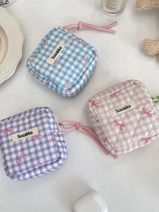 Quilted plaid coin purses in blue, pink, and purple colors displayed on a clean tabletop