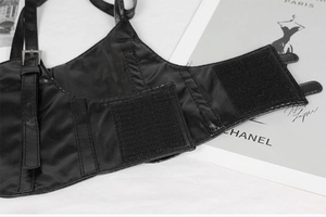 Detail of black faux leather corset belt showing velcro closure and adjustable straps