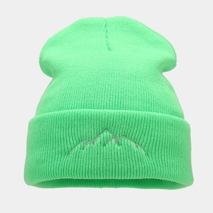 Close-up of neon green knit beanie featuring a grey mountain embroidery detail