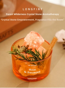 Detail of crystal stone oil diffuser with cinnamon sticks in warm orange glass jar