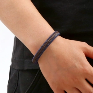 Close-up of woven leather bracelets in navy blue and brown on a male model wrist