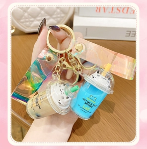 Detail of cat milk tea cup keychains with liquid filling and iridescent hand straps