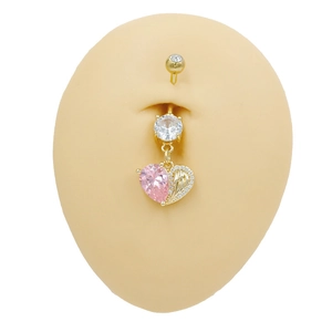 Detail showing a heart-shaped pink zircon belly ring with wings on a silicone model