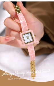 Details einer eleganten rosa Kunstharzuhr mit Goldarmband und funkelnden Strasssteinen