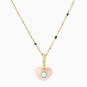 Close-up of pink heart pendant with gold chain and colorful bead accents on white background