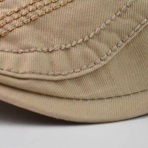 Close-up of khaki cotton twill fabric with parallel stitching on a flat cap brim