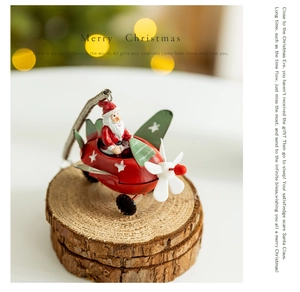 Macro shot of metal Santa Claus airplane ornament on wooden base with bokeh background
