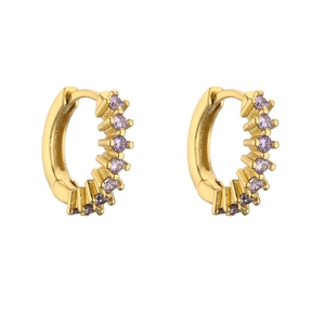 Macro shot of gold-plated huggie earrings with a row of inlaid purple cubic zirconia