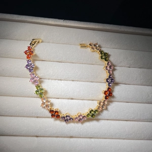 Detailed top view of rainbow clover bracelet with colorful zircon stones in a jewelry box