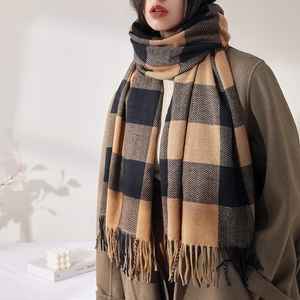 Sciarpa a quadri in cashmere nero e cammello con frange indossata da una modella
