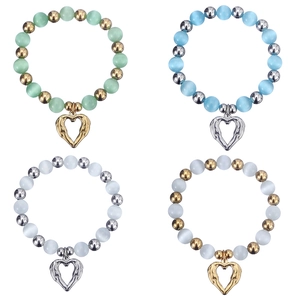 Detail of beaded bracelets featuring cat eye stones and hollow heart metal pendants