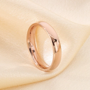 Polished rose gold minimalist titanium ring displayed on champagne satin fabric