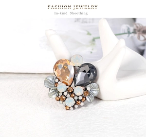 Macro shot of boho crystal brooch with amber water-drop gems on a ceramic hand stand