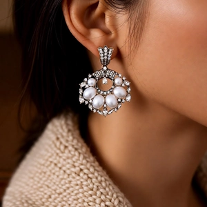 Close-up of vintage gold pearl drop earrings featuring intricate crystal detailing