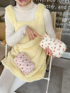 Quilted makeup bags featuring cute floral and bear prints held in a lifestyle setting
