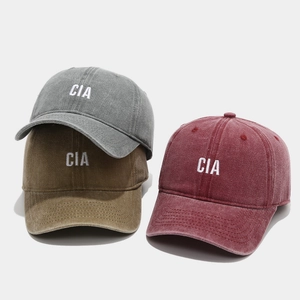 Three washed cotton baseball caps with CIA embroidery in grey, brown, and burgundy colors