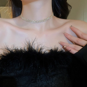 Close-up of gold layered choker with rhinestones on model for a trendy styling view