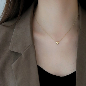 Polished 18K gold plated 925 sterling silver heart necklace worn with stylish brown suit