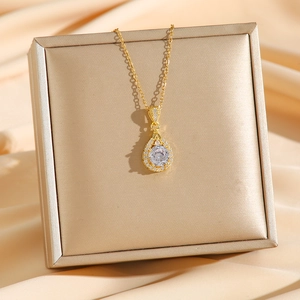 Luxurious gold teardrop pendant necklace with sparkling diamonds on a silk display