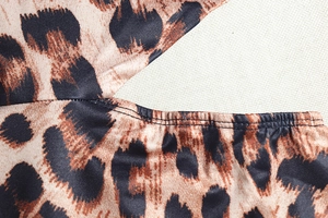 Detailed close-up of leopard print fabric showing fine stitching and hollowed-out design