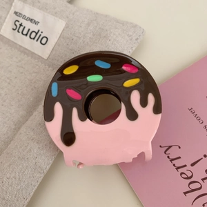 Macro detail of donut hair claw clip with pink base and chocolate drizzle design