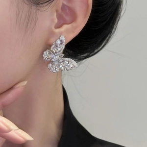 Sparkling silver butterfly earrings with cubic zirconia stones worn by a model