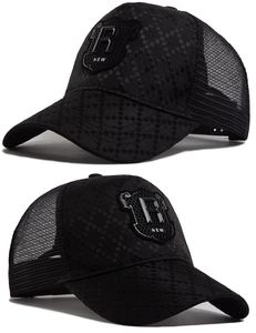 Detailed close-up of a black trucker hat with 3D shield logo and breathable mesh