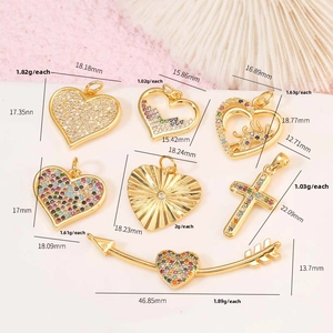 Detailed view of 14K gold heart pendants and crosses inlaid with colorful cubic zirconia
