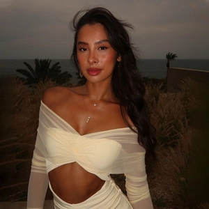 Détail d'une robe beige à manches en mesh avec découpes d'épaules et taille ajourée