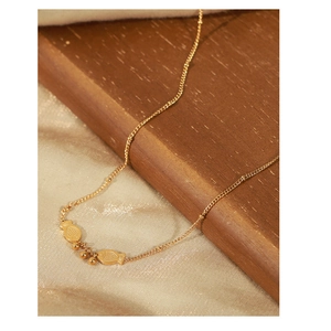 Detail shot of golden fish pendant necklace on elegant silk and wooden background