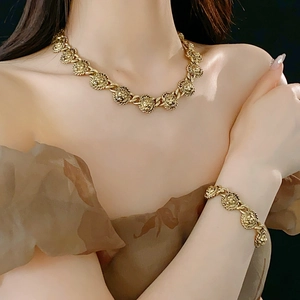 Détail macro de la parure vintage collier et bracelet tête de lion dorée