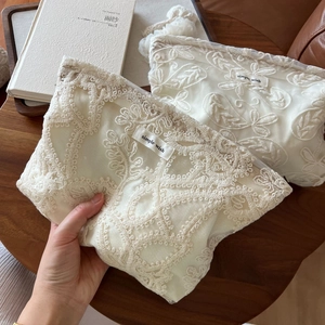 Détail de la trousse de toilette en dentelle brodée avec étiquette simple wish