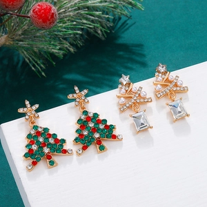 Sparkling Christmas tree earrings set with colorful rhinestones and pearls on white wood