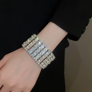 Macro shot of wide multi-row silver bracelet with crystals on a model's wrist