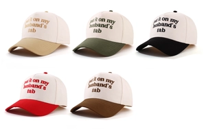 Close-up of five color-block baseball caps with vintage embroidery on white canvas crowns