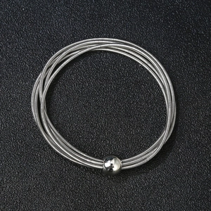 Unisex stainless steel spring bracelet with a polished silver ball charm on black background