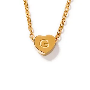 Detail of gold heart pendant with letter G engraving and fine necklace chain link