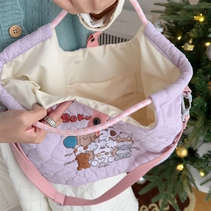 Detail of purple quilted bag interior showing lining, zipper pocket and metal snap button