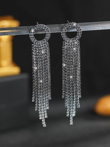Macro shot of elegant silver rhinestone fringe earrings with shimmering long tassels
